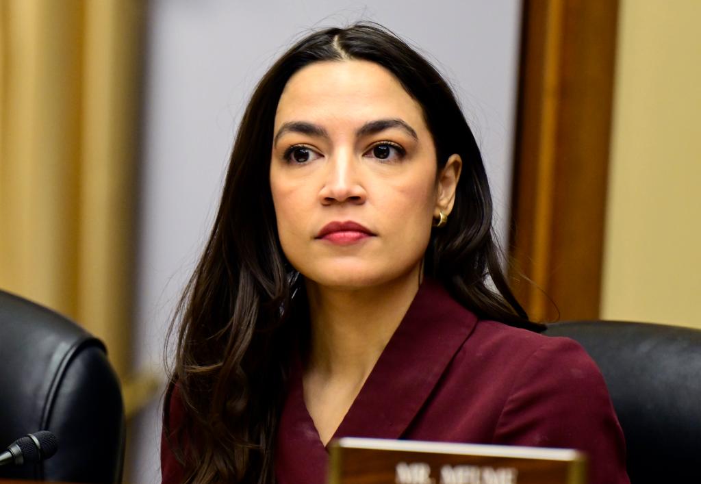 Alexandria Ocasio-Cortez in a purple suit at the United States House Committee on Oversight and Accountability hearing titled 'Influence Peddling: Examining Joe Biden's Abuse of Public Office'