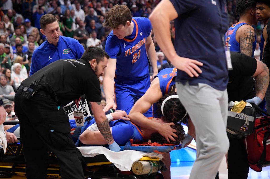 Florida teammates console Micah Handlogten as he's stretchered off with a leg injury.