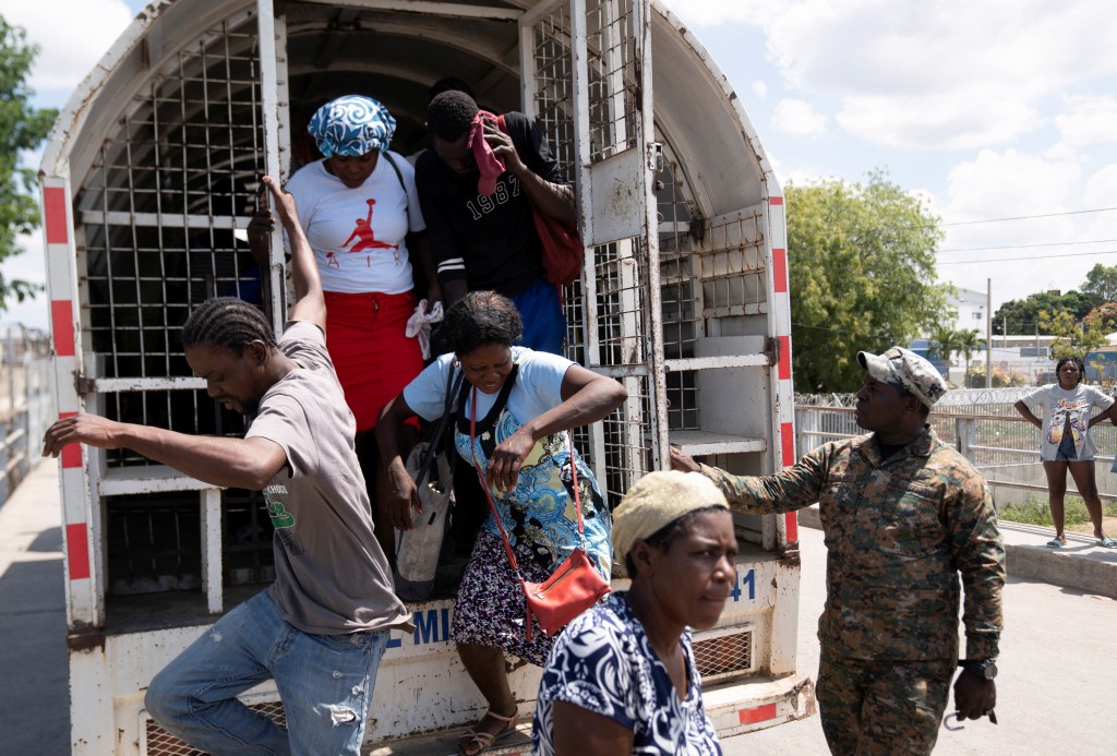 Haitian citizens get off a truck to be deported on the border between Haiti and Dominican Republic.