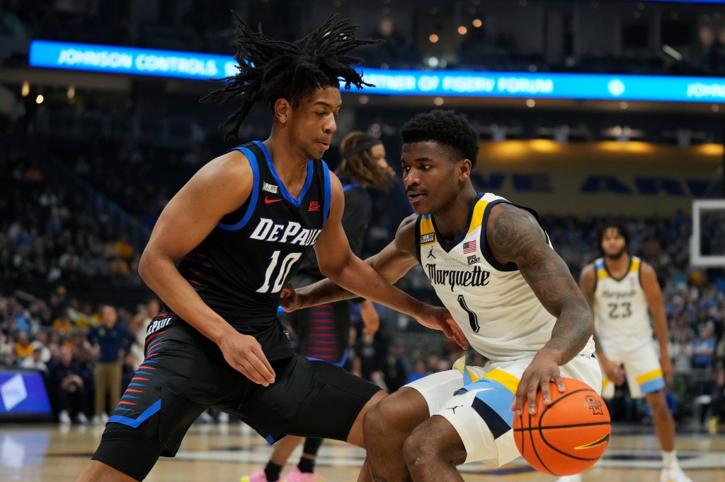 Kam Jones #1 of the Marquette Golden Eagles is defended by Jaden Henley #10 of the DePaul Blue Demons during the first half at Fiserv Forum.