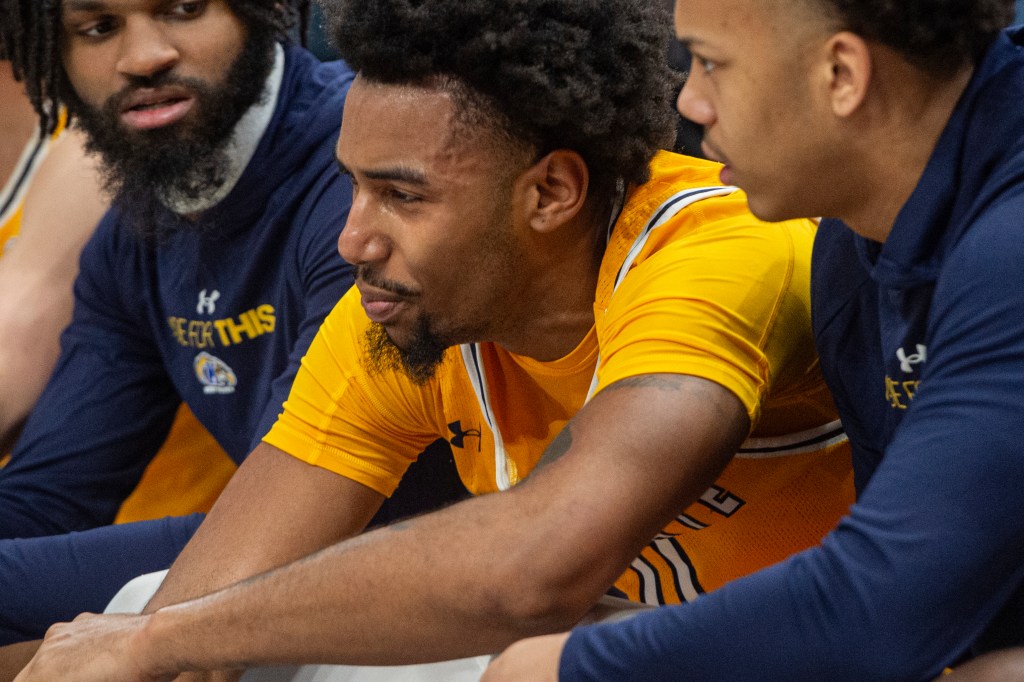 Kent State's Julius Rollins and teammates react on the bench after foul against Akron in MAC Championship Basketball game.