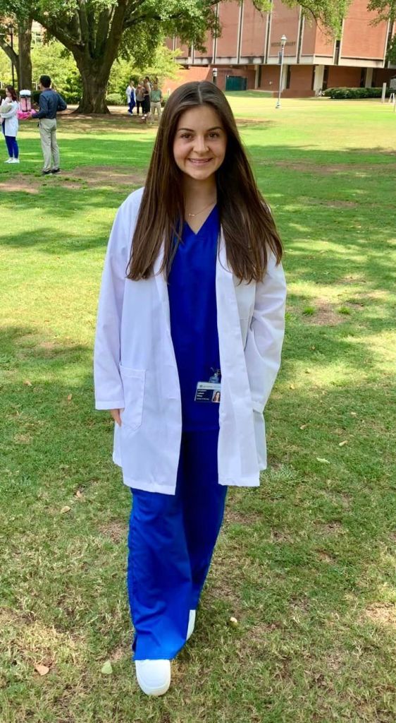 A young woman wearing a white coat.