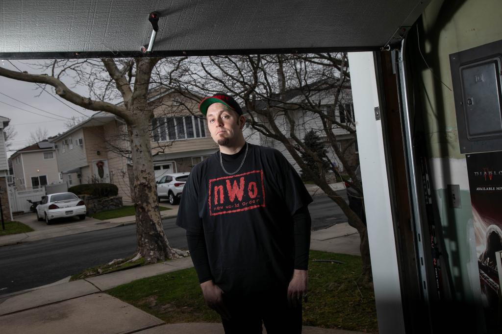 A photo of Hickey clad in black slacks, an NWO T-shirt and baseball style cap.