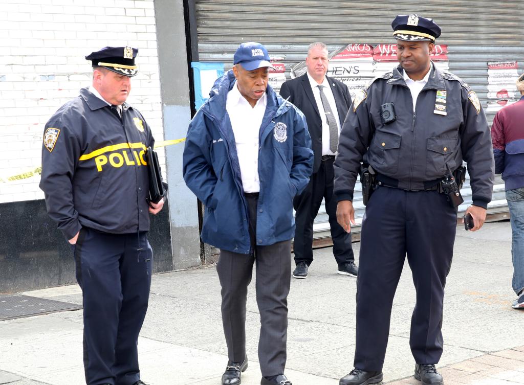 A photo of Mayor Adams with investigating officers at the crime scene.