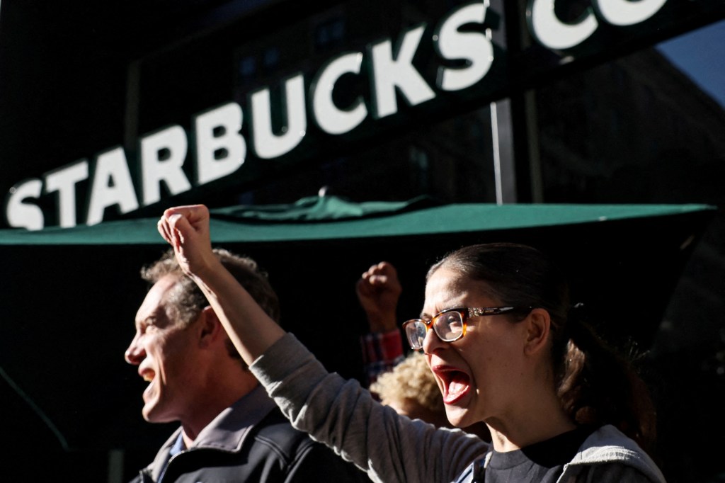 Members of the Starbucks Workers Union picketing and holding a rally outside a Starbucks store during Red Cup Day event.