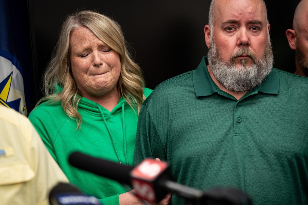 Michelle Strain Whiteid, mother of Riley Strain, holds onto the arm of her husband, Chris Whiteid, during a press conference at the Metro Nashville Police Department Headquarters in Nashville, Tennessee.