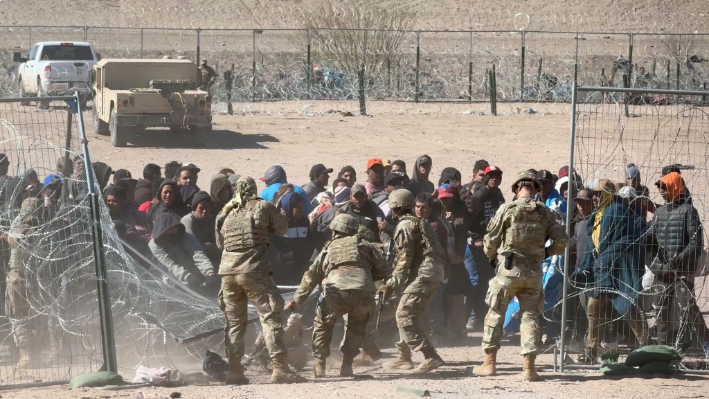 The migrants broke through a fence with razor wire.