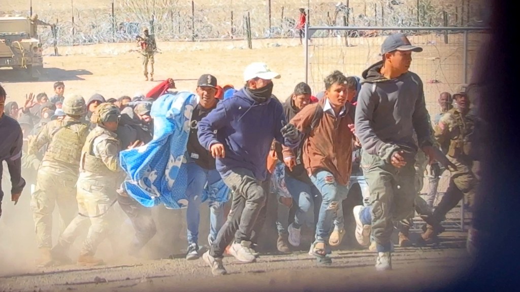 The large crowd of migrants rushed past the Texas National Guard.