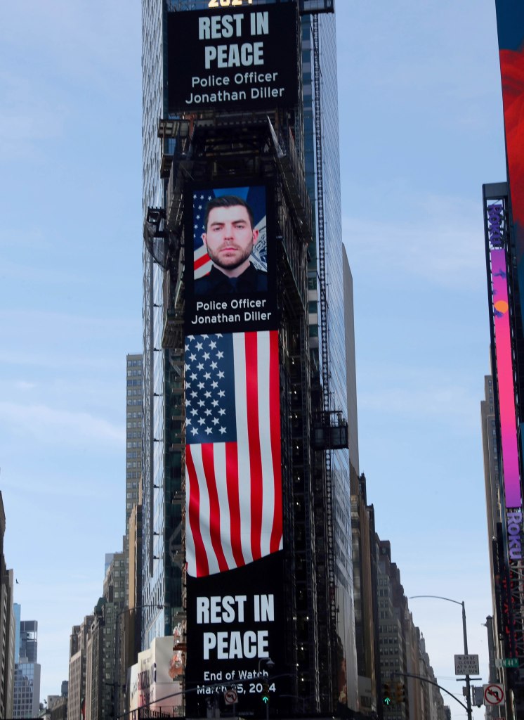 Photo of: New York City Police Officer Jonathan Diller were a large billboard overlooks the Police Substation at One Times Square