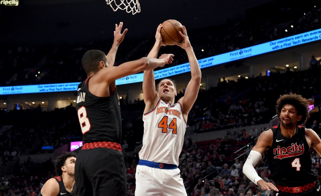 Bojan Bogdanovic, center, shoots a basket over Portland Trail Blazers forward Kris Murray, front left, as Trail Blazers guard Matisse Thybulle, right, defends during the first half.