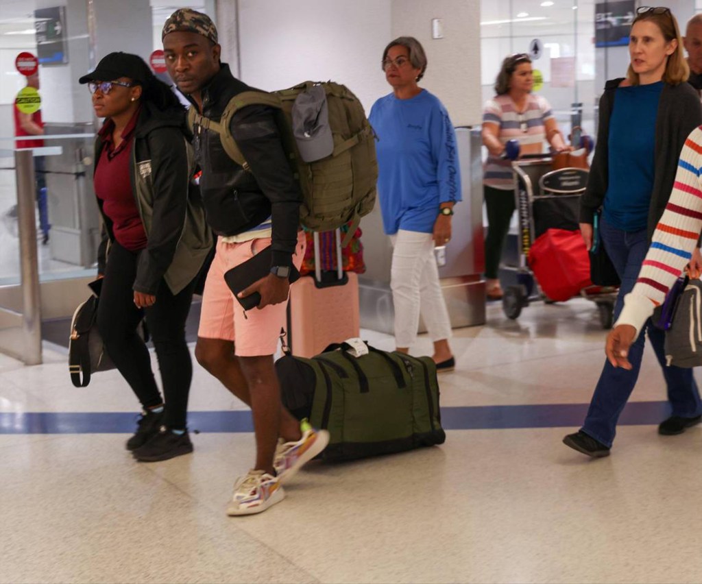 Passengers walk through the Arrivals area after arriving on the first evacuation flight out of Cap-Haitien, Haiti, at Miami International Airport on Sunday, March 17, 2024. 