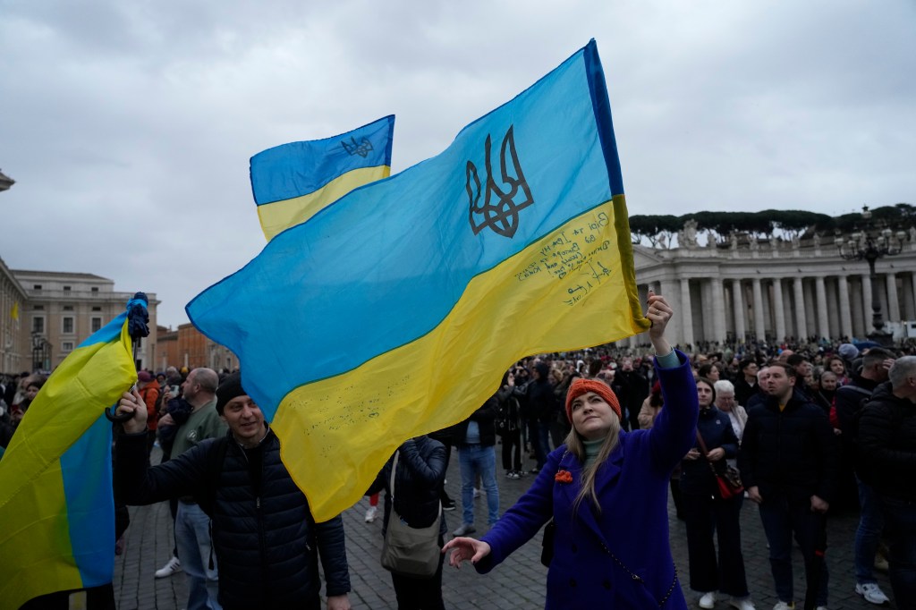 A civilian waves a Ukrainian flag