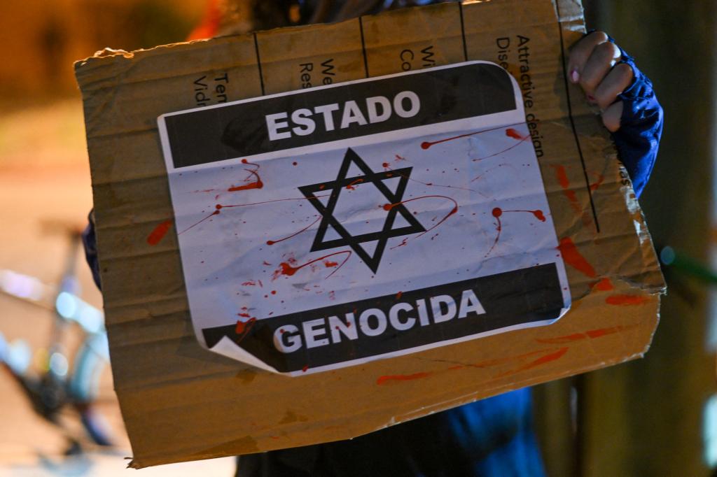 Protester holding a sign reading 'genocidal state' during a cycling protest in Guatemala City, in support of the Palestinian people amidst conflict