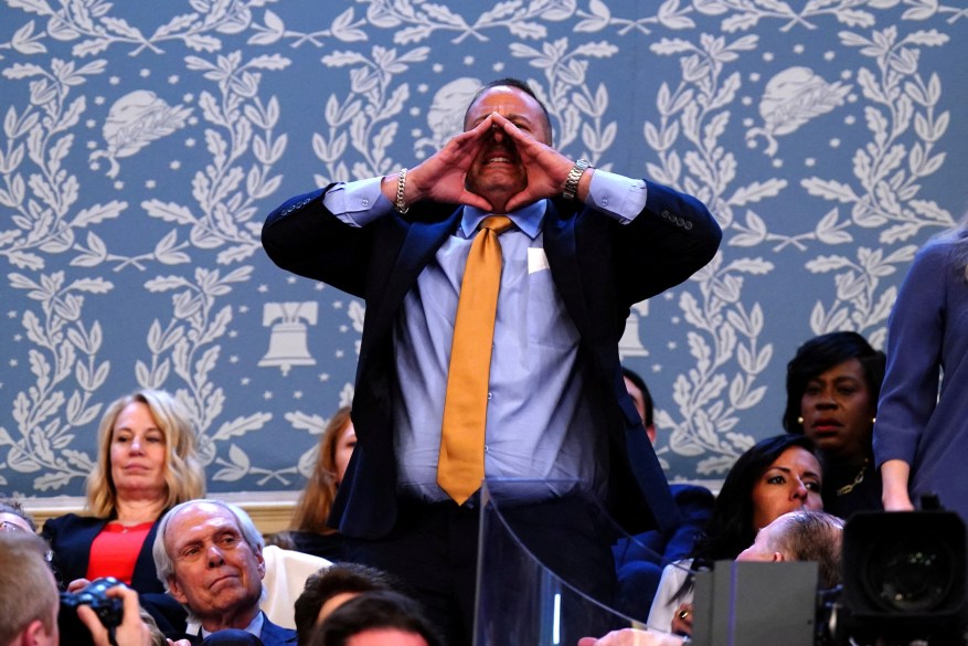 Steve Nikoui, the father of a fallen Marine, shouts during the address.