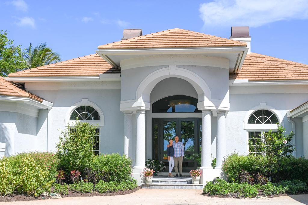 The Weathersbys in front of their handsome home.