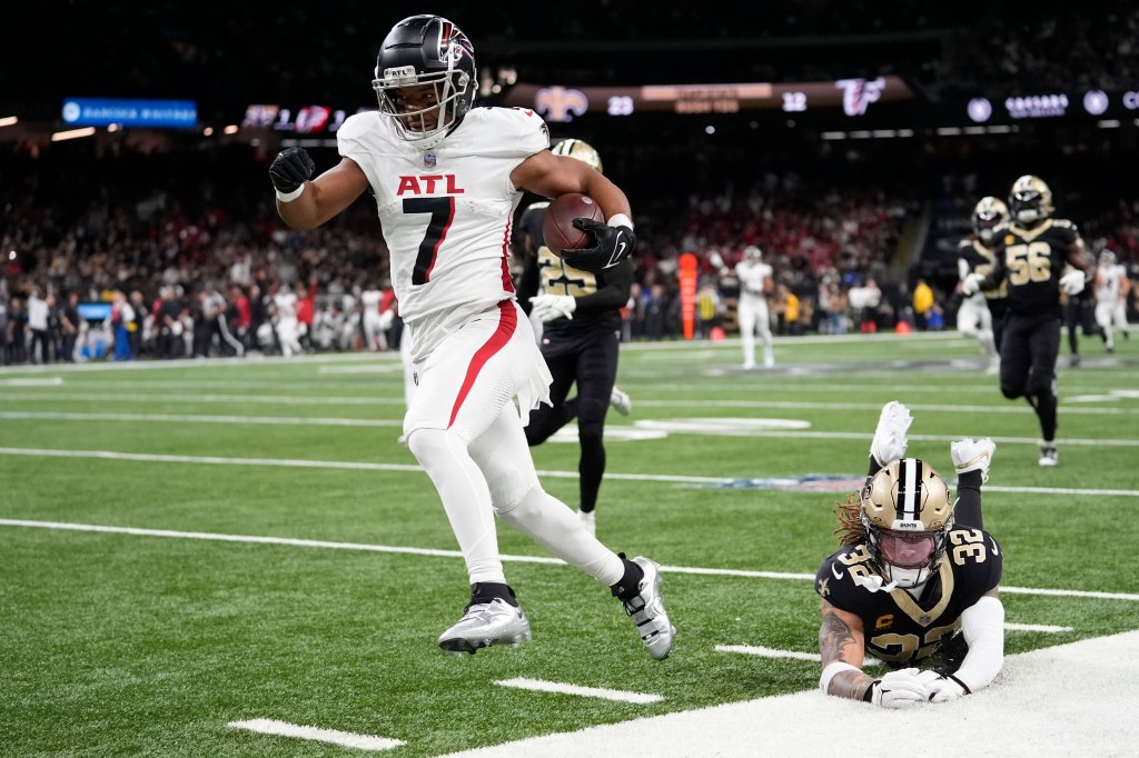 Atlanta Falcons running back Bijan Robinson (7) runs in for a touchdown against New Orleans Saints safety Tyrann Mathieu (32) in the first half of an NFL football game against the New Orleans Saints in New Orleans, Sunday, Jan. 7, 2024.  