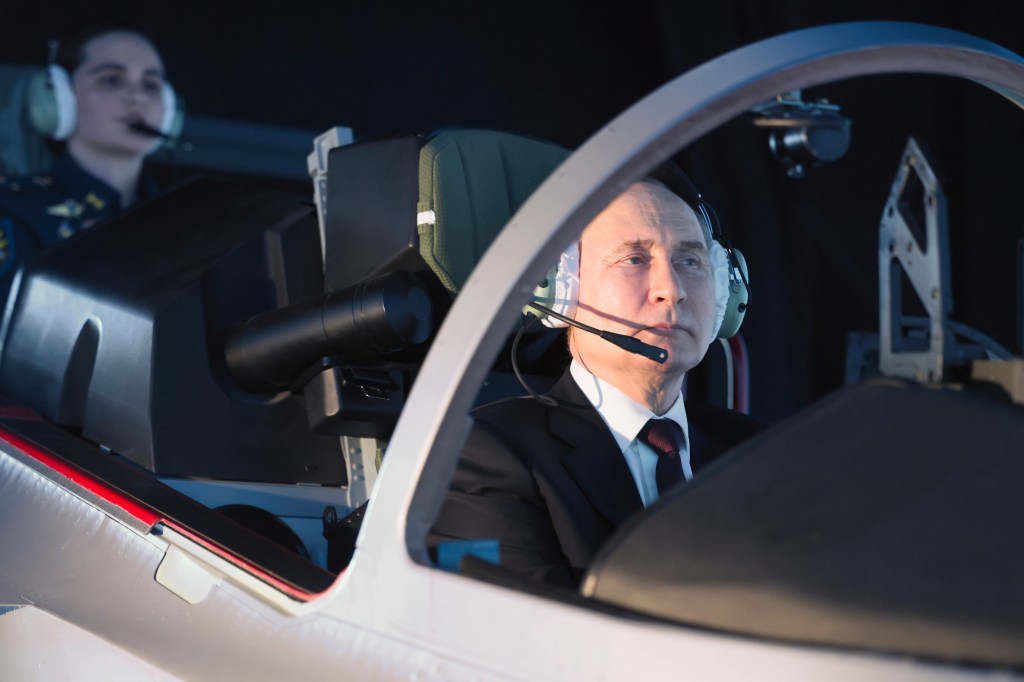 Russian President Vladimir Putin sits in a cockpit of a flight simulator at the Krasnodar Higher Military Aviation School of Pilots named after Anatoly Serov in Krasnodar, Russia, Thursday, March 7, 2024.