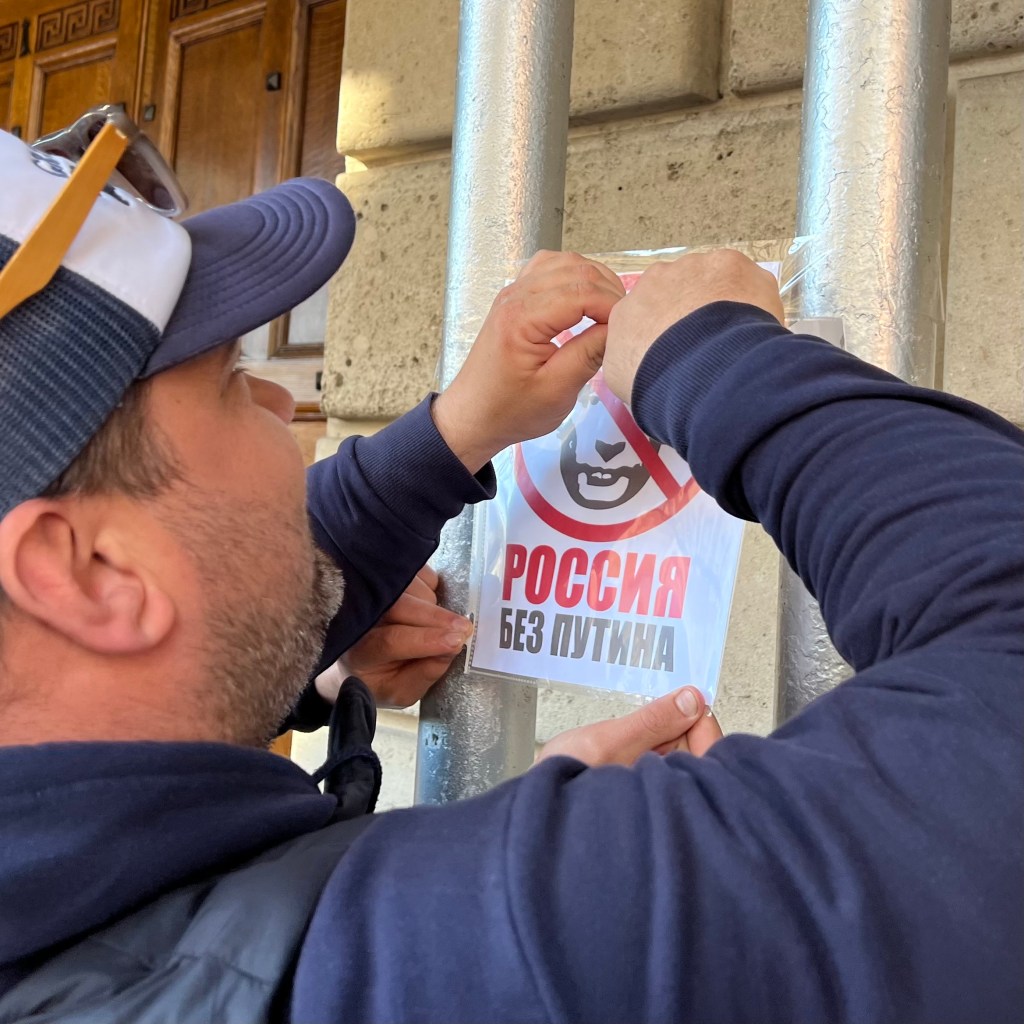 Man putting up an anti-Putin poster