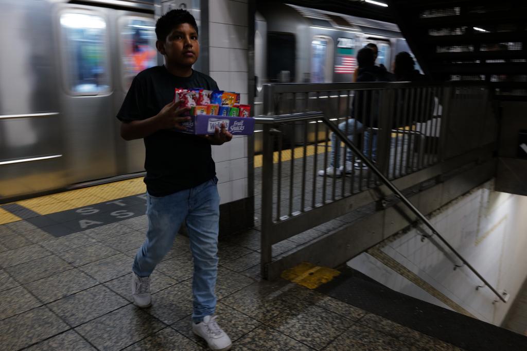 Migrant boy sells candy in the subway.