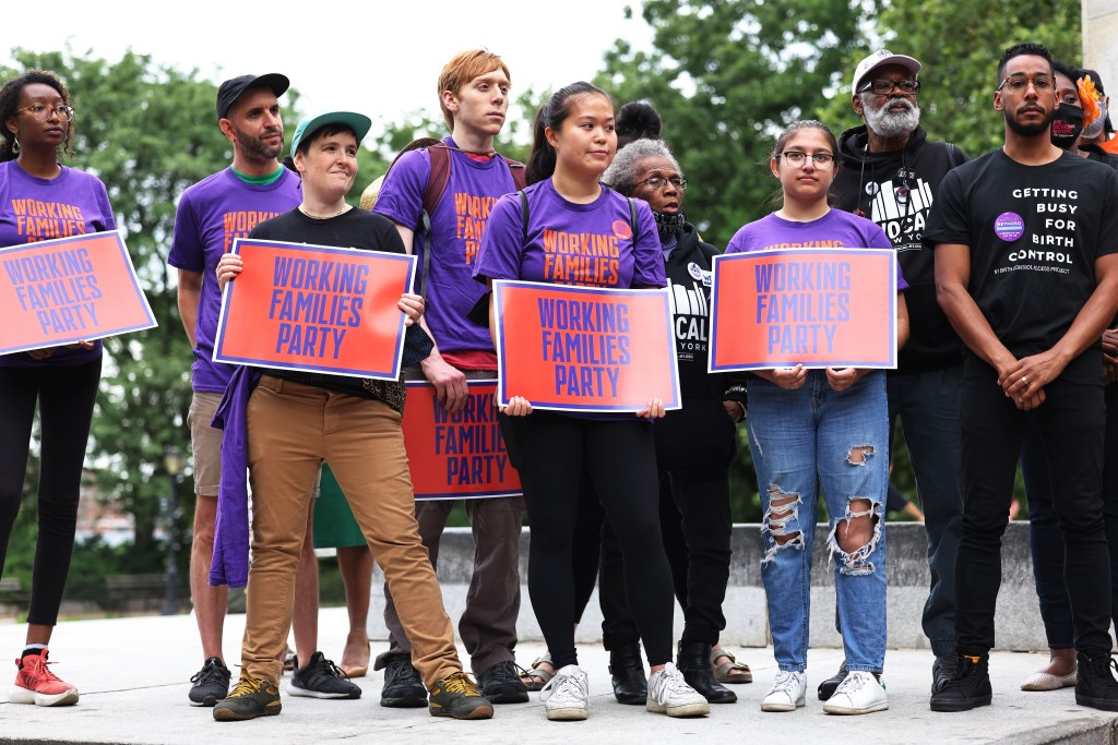 People hold signs during a New York Working Families Party GOTV Rally for their endorsed candidates in Fort Greene Park on June 11, 2021 in the Fort Greene neighborhood of Brooklyn borough in New York City