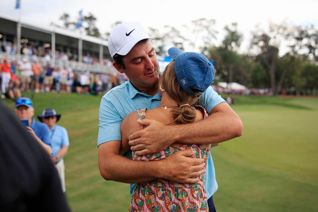 Scottie Scheffler hugs his wife Meredith Scudder after winning the tournament on hole 18 during the fourth and final round of The Players golf tournament Sunday, March 12, 2023 at TPC Sawgrass in Ponte Vedra Beach, Fla.