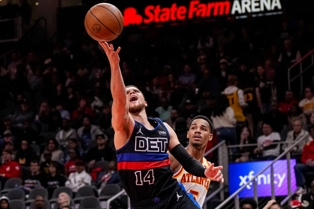 Detroit Pistons guard Malachi Flynn (14) scores behind Atlanta Hawks guard Dejounte Murray (5) during the second half at State Farm Arena.