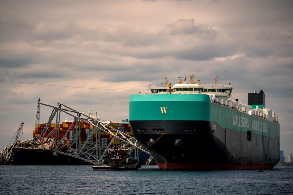 Cargo ship moves past Baltimore Key Bridge wreckage.