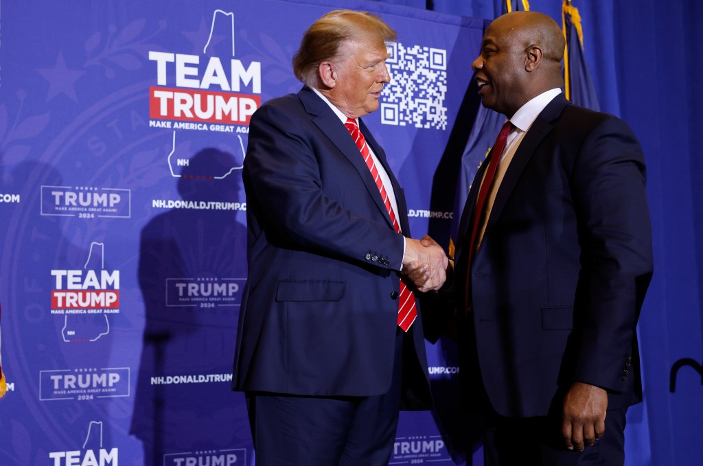 Sen. Tim Scott (R) (R-SC) shakes hands with Republican presidential candidate and former President Donald Trump during a campaign rally at the Grappone Convention Center on January 19, 2024 in Concord, New Hampshire. 