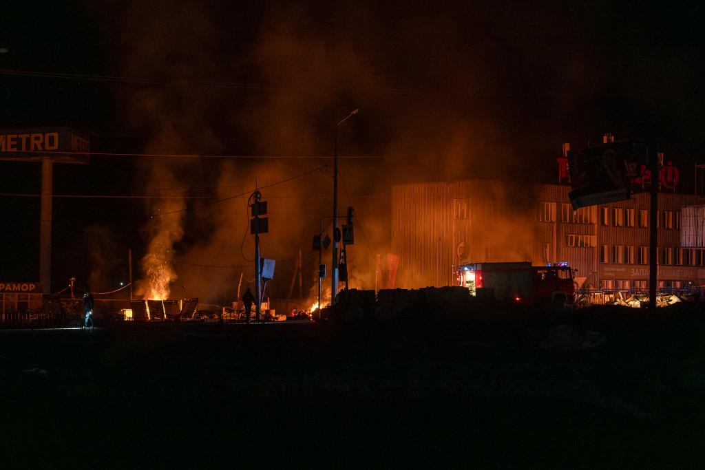 Rescue workers extinguish the fire at the site of a Russian drone attack in Kharkiv, Ukraine, early Saturday.