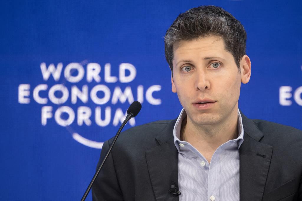 OpenAI CEO Sam Altman standing in front of a microphone at the World Economic Forum meeting in Davos, January 18, 2024.