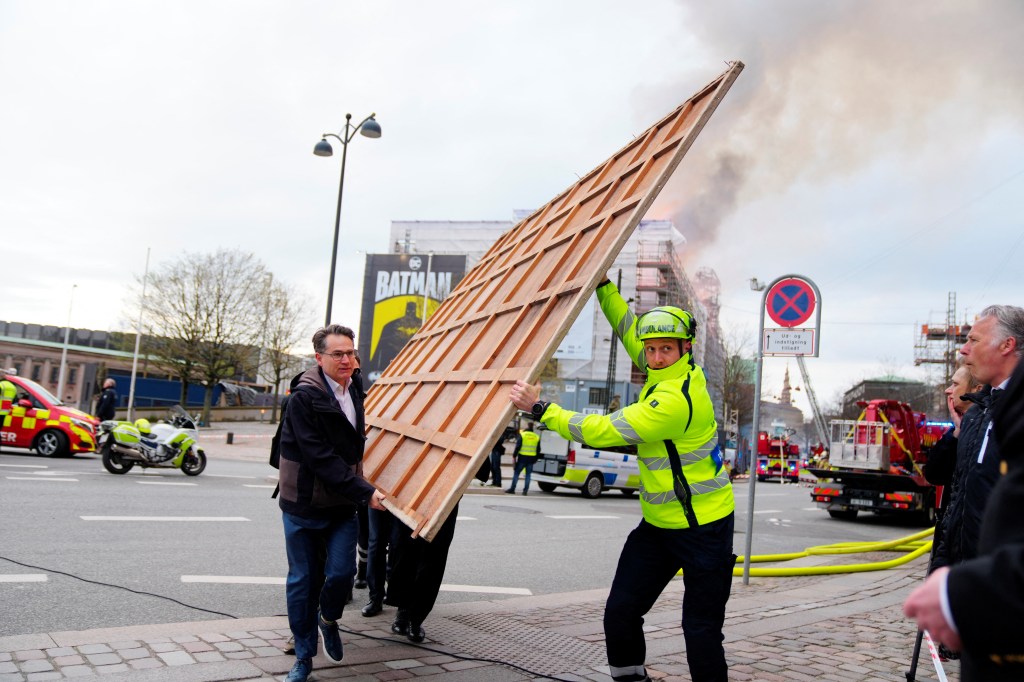 Emergency worker and people removing paintings and other objects from the historic Old Stock Exchange, Boersen, during a fire in Copenhagen, Denmark.