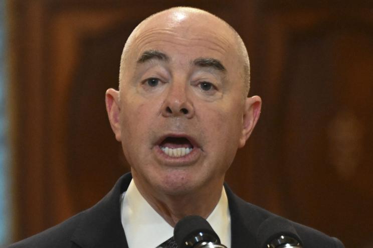 Homeland Security Secretary Alejandro Mayorkas speaking into a microphone during a joint press conference in Guatemala City