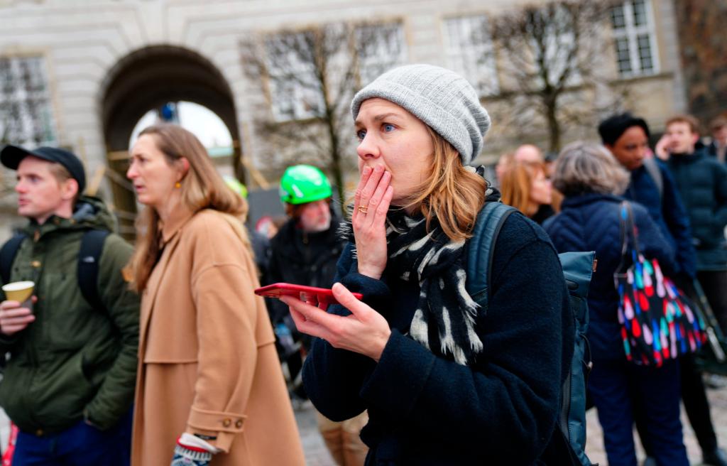 People react to a fire in the historic Boersen building in central Copenhagen, Denmark, on April 16, 2024. 