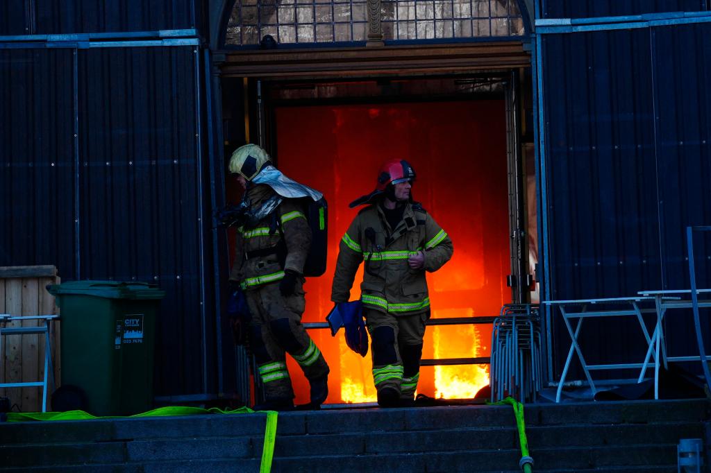 Firefighters work at the main entrance of the historic Boersen stock exchange building which is on fire in central Copenhagen, Denmark on April 16, 2024. 