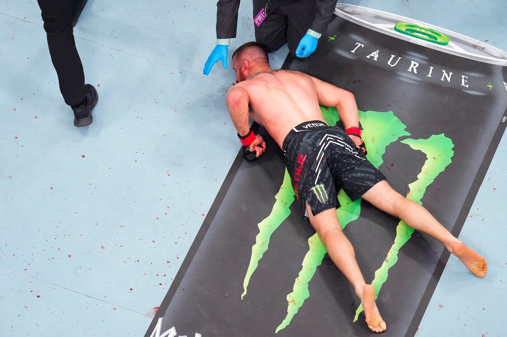 Justin Gaethje lays flat on the canvas after being knocked out with one second to go in his fight against Max Holloway.