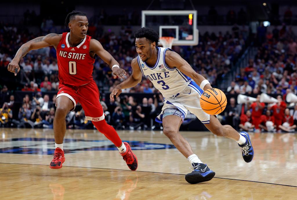 Jeremy Roach drives to the basket as DJ Horne #0 of the North Carolina State Wolfpack defends in the Elite 8 round of the NCAA Men's Basketball Tournament at American Airlines Center.