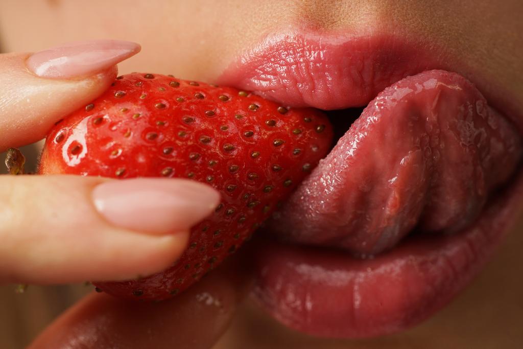 Sexy womans lips. Erotic concept. Sexy lips with strawberries. Oral sex. Erotic woman secret and sex symbols concept. Orgasm. Talk sex. Strawberry lubricant