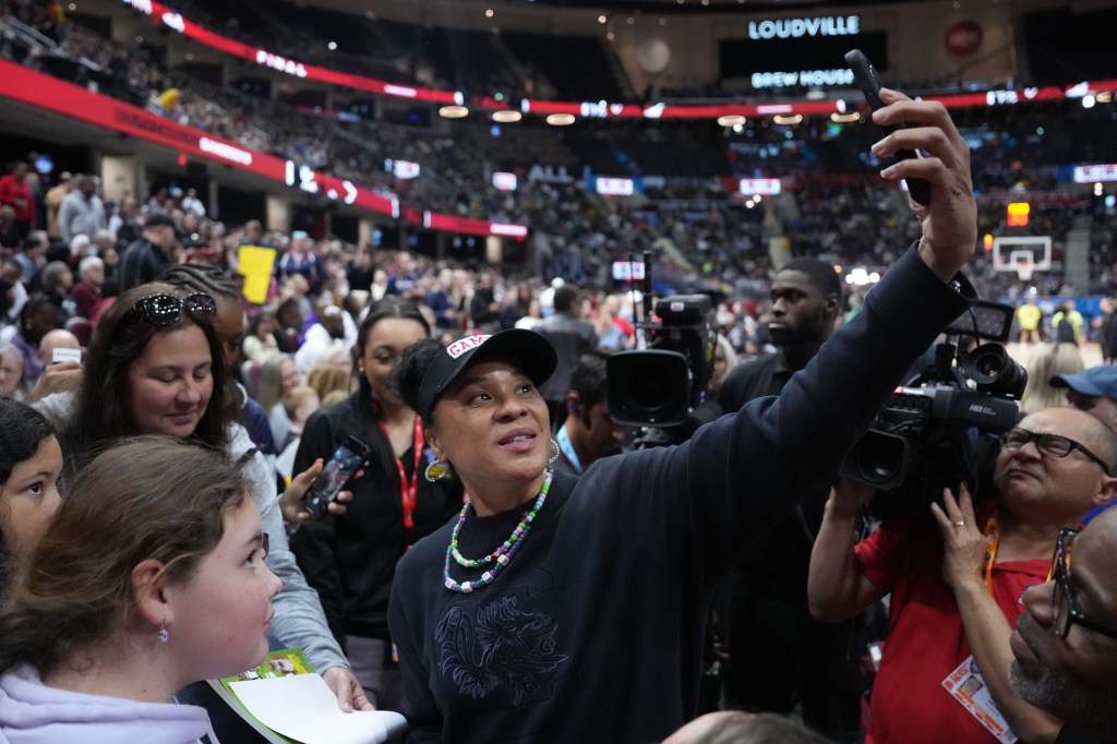 South Carolina coach Dawn Staley poses for a selfie with fans during a practice in preparation for Sunday's national title game against Iowa.