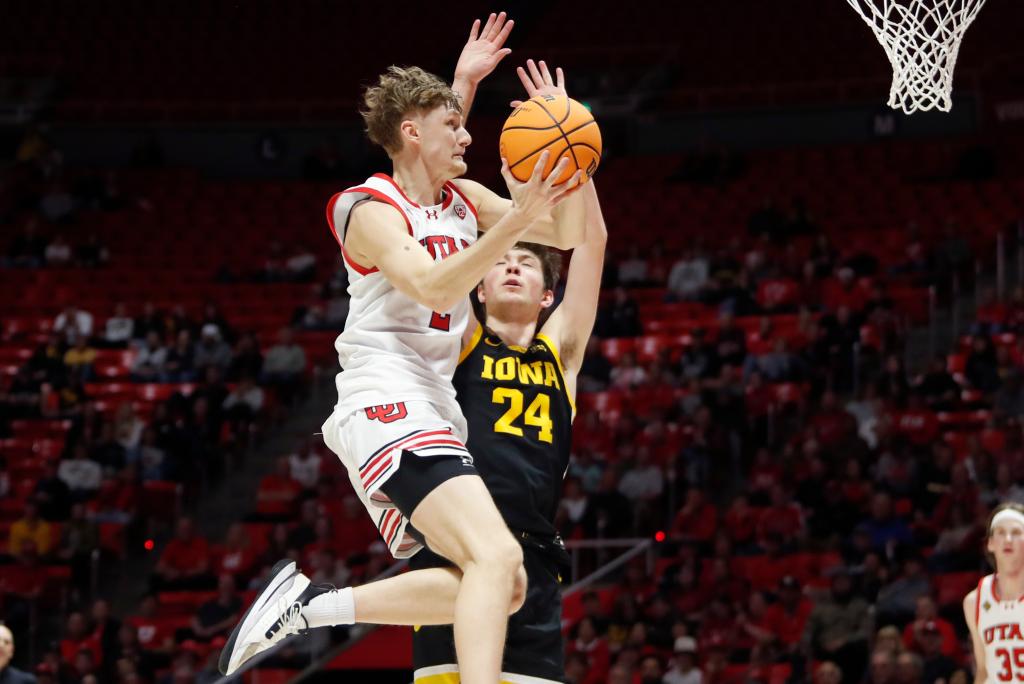 Cole Bajema #2 of the Utah Utes drives to the basket against Pryce Sandfort #24 of the Iowa Hawkeyes during the second half of the second round of the men's basketball National Invitation Tournament.