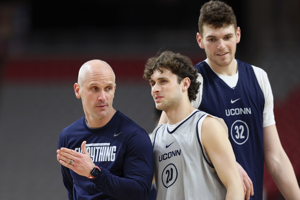 UConn coach Dan Hurley talks things over with Andrew Hurley during practice on Friday as Donovan Clingan looks on.