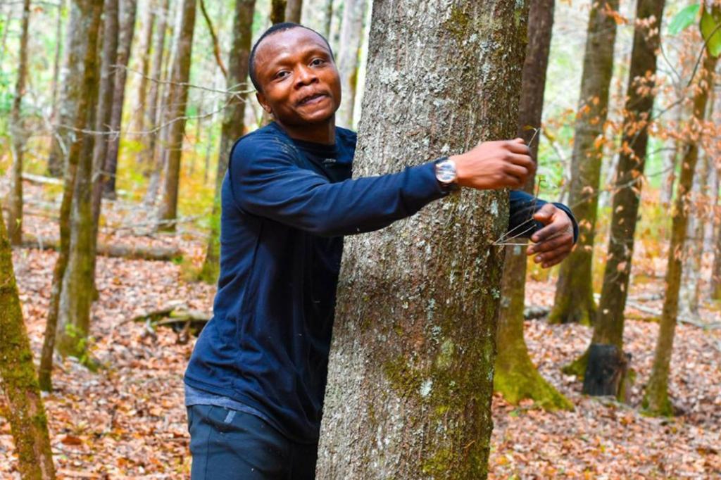 Abubakar Tahiru hugging a tree.