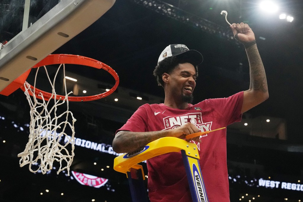 Crimson Tide guard Aaron Estrada (55) cuts the net after defeating the Clemson Tigers in the finals of the West Regional