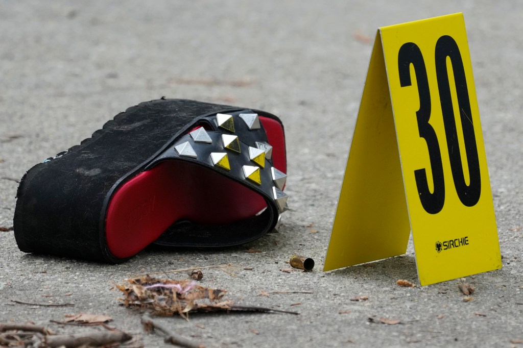 An evidence marker is place next to a cartridge case at the scene of a shooting at an Eid event 