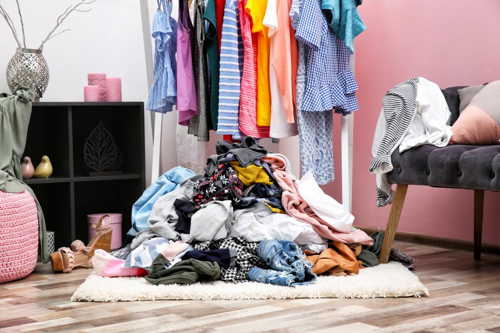 Messy dressing room interior with a pile of clothes on the rack