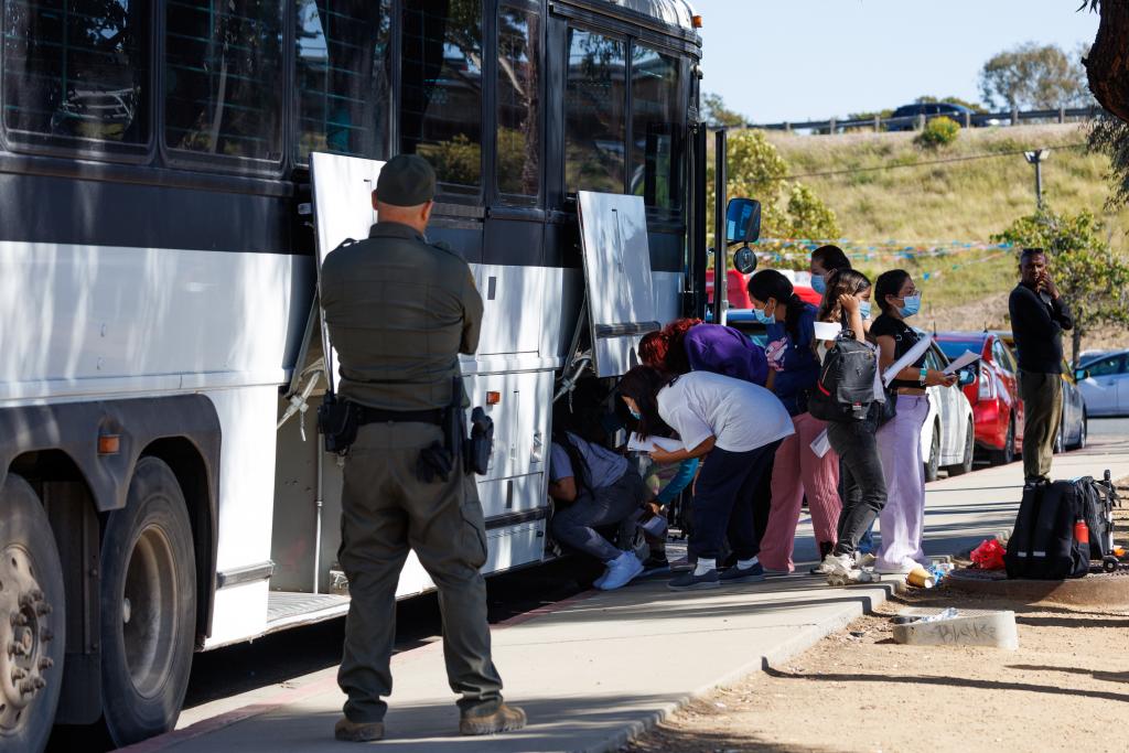 Migrants are dropped off by Border Patrol at the Iris Transit Center in San Diego, California