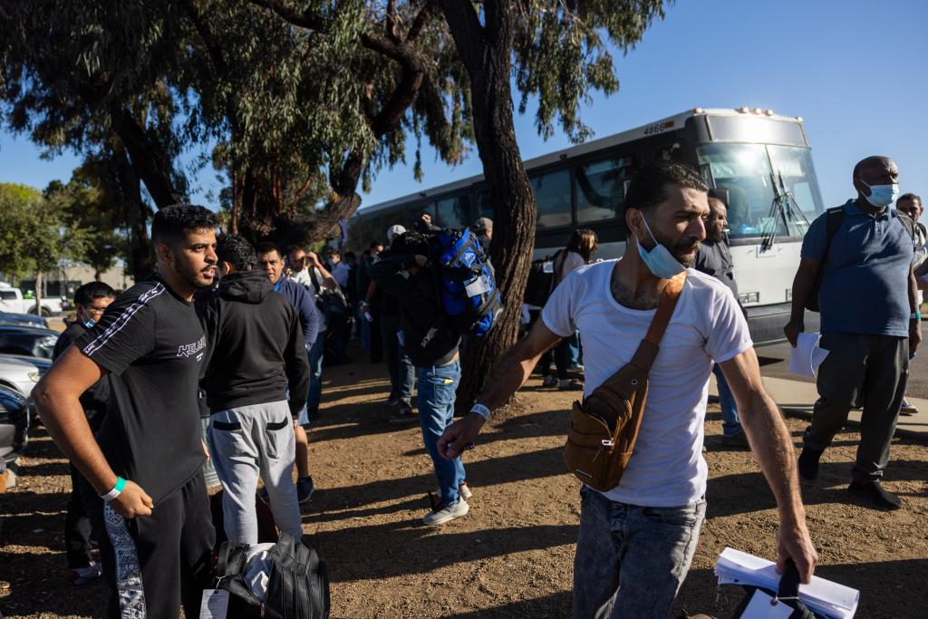 Migrants are dropped off by Border Patrol at the Iris Transit Center in San Diego, California