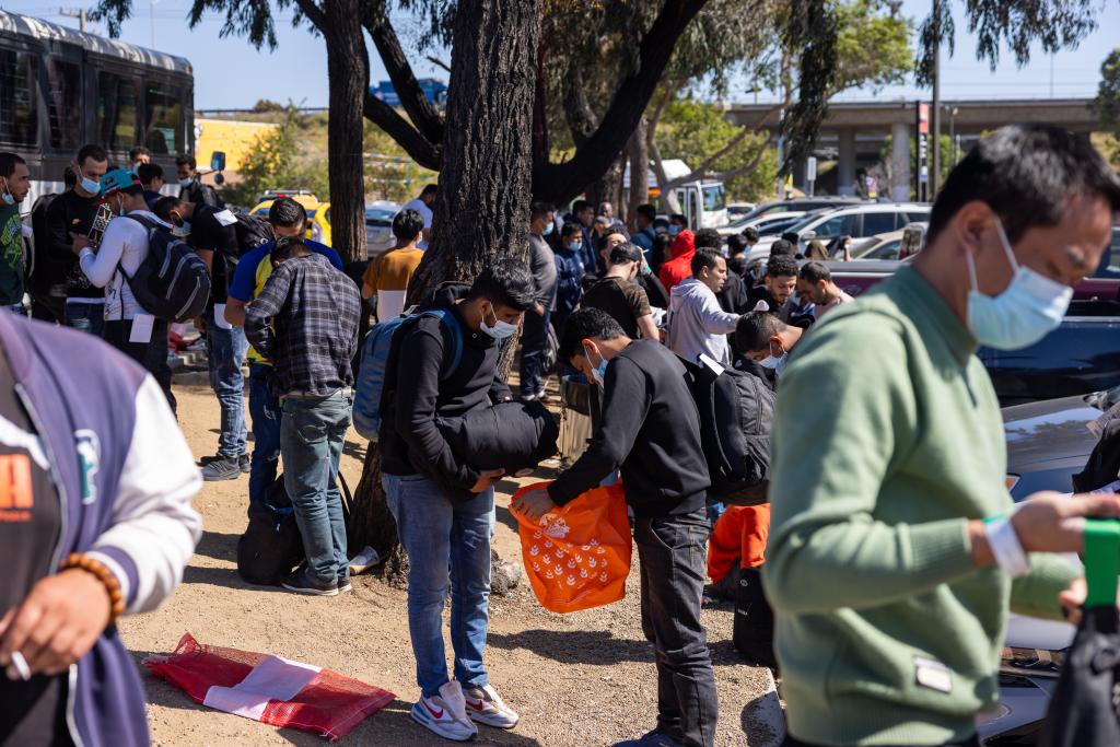 Migrants being dropped off by Border Patrol at the Iris Transit Center in San Diego, California, guided by NGO volunteers towards San Diego Trolley