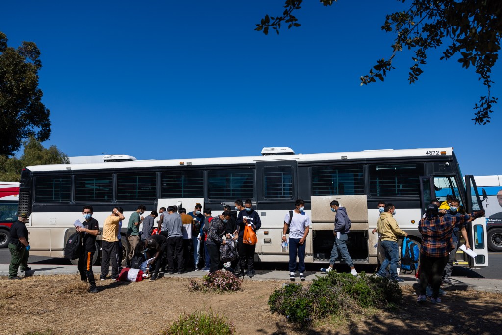 Migrants are dropped off by Border Patrol at the Iris Transit Center in San Diego, California