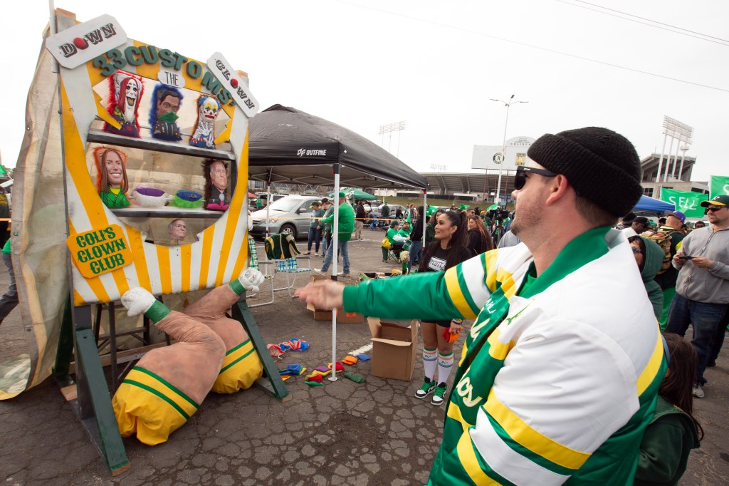 An Oakland Athletics fan throws beanbags at a "rogues gallery" to protest ownership plans to move the franchise to Las Vegas