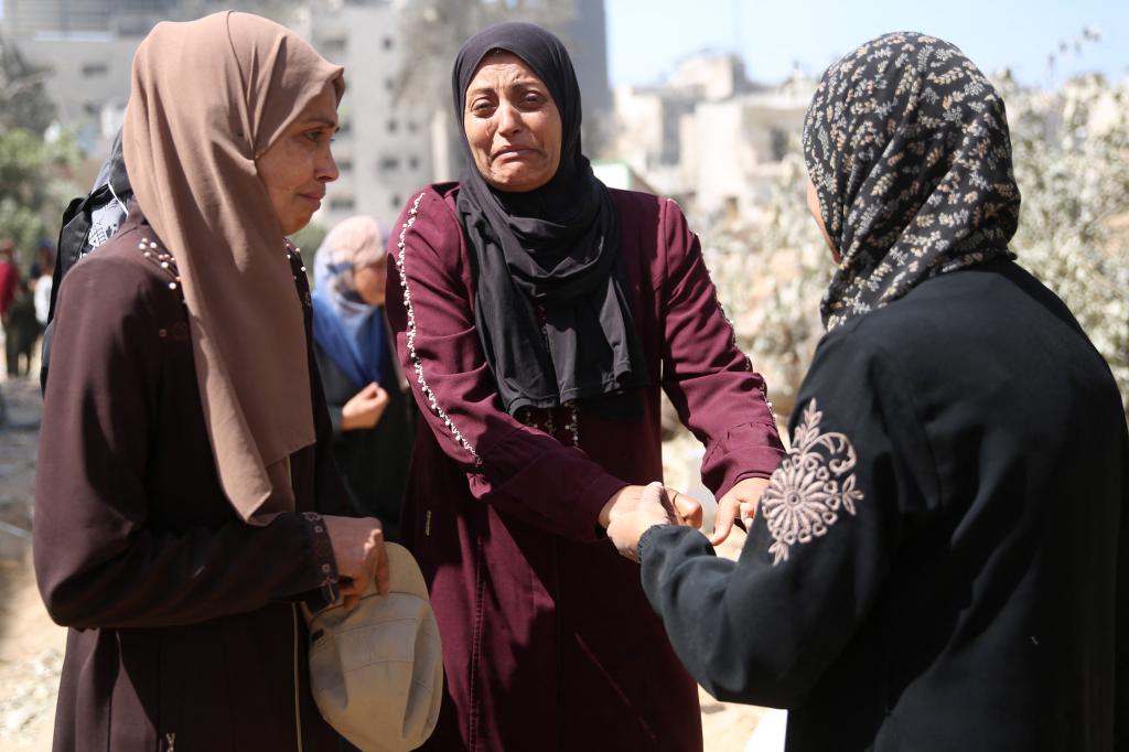 Palestinian women react as they inspect the damage in the area surrounding Gaza's Al-Shifa hospital